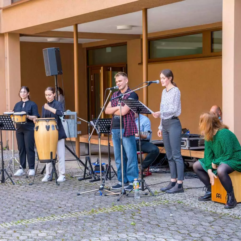 Mehrere Schüler der Schulband an Instrumenten und Mikrofonen.